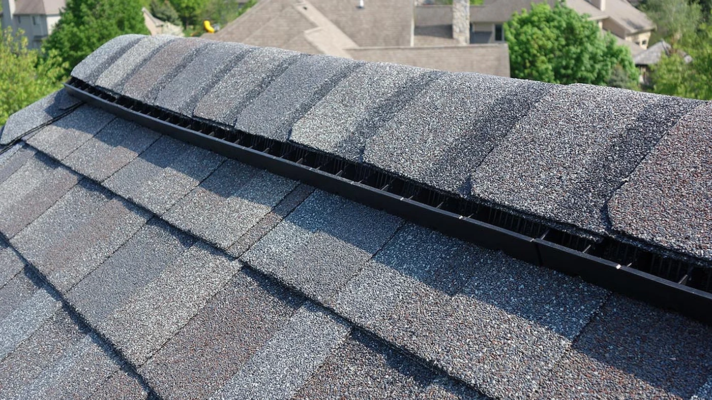 Ridge ventilation detail beneath architectural asphalt shingles on a Charlotte NC roof