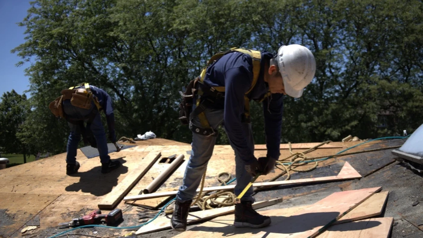 Roofers replacing exposed roof decking during a Charlotte NC roof replacement
